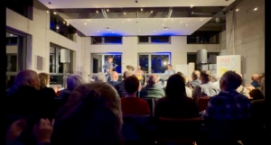 Matti Klein spielt mit Band vor Publikum im Home Duisburg, Blick aus dem Zuschauerraum auf die beleuchtete Bühne.